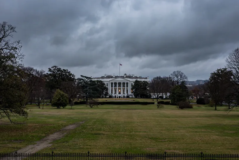 The White House in Washington, DC at dusk under heavy gray clouds